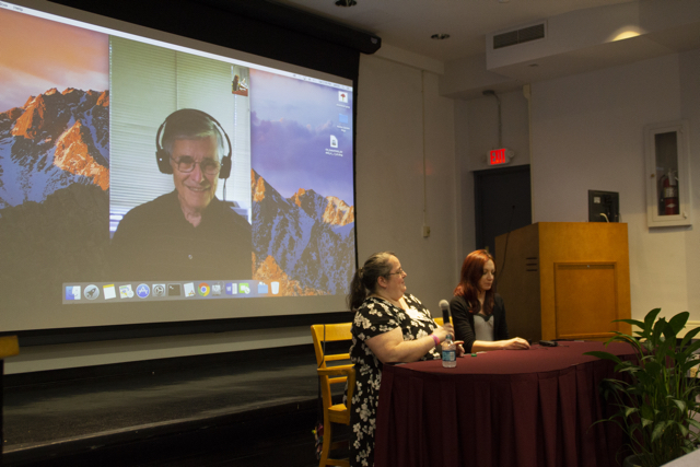 Photo of Richard Hill speaking remotely to a genealogy group on a large screen